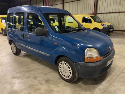 La petite camionnette bleue est garée dans un garage avec d'autres voitures.