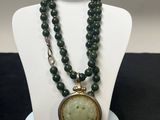 un gros plan sur un collier porté par un mannequin, avec la photo d'une femme