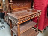 a wooden desk with a red curtain in the background