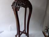 a small wooden table with a vase on top of it