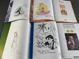 a lot of books that are open on a table