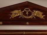 a bed with a wooden headboard and a mirror above it