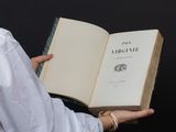someone is holding a book in their hands with a black background
