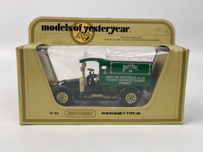 un petit camion vert dans une boîte, posé sur une surface blanche