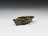 une ancienne figurine en bronze représentant un bateau sur un fond blanc