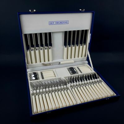 un coffret bleu contenant de l'argenterie, sur fond noir
