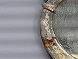 un miroir argenté orné d'un motif floral