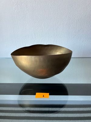 un bol en or posé sur une table en verre