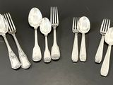 six silver spoons and six forks are lined up on a black surface