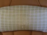 a tan and white checkered bag sitting on a brown leather chair