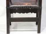 a wooden chair with a leather seat on a white background