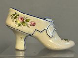a white shoe with blue trim and flowers on it