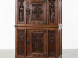 une vieille armoire en bois avec des sculptures et des gravures sur les portes