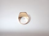 an image of a gold ring on a white surface