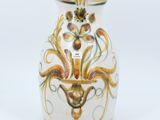 a white vase with a gold and green design on it