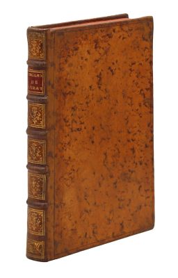 un vieux livre à la couverture brune posé sur une surface blanche