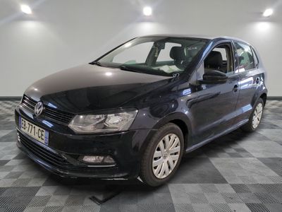 La Volkswagen Polo noire est garée dans une pièce au sol carrelé en damier.