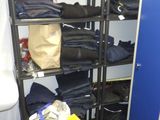 un casier bleu dans une pièce où se trouvent plein de vêtements