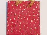 un sac rouge orné d'étoiles dorées, posé sur une surface blanche