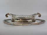 un plateau ancien en argent avec un bol en verre posé dessus