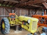 un tracteur garé dans une grange avec d'autres tracteurs
