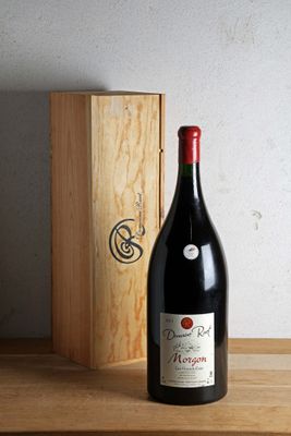 une bouteille de vin posée sur une table à côté d'une caisse en bois