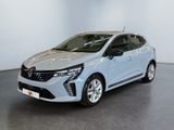 Une voiture bleue est garée dans une pièce blanche au sol noir.