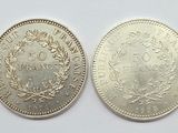 a close up of two silver coins on a white surface