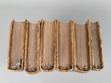 six old books stacked on top of each other on a table