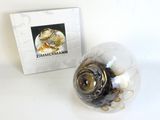 a glass ball with coins inside of it next to a box