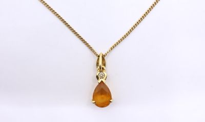 a yellow necklace with a tear shaped pendant on a gold chain