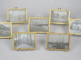 Six photos encadrées représentant des bateaux sont accrochées au mur.