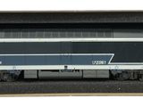un petit train posé dans une boîte sur une surface blanche