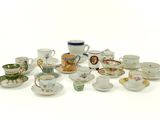 many cups and saucers sitting on a white surface