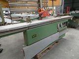 a machine that is cutting a piece of wood in a factory