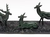 three statues of deer that are sitting on a table
