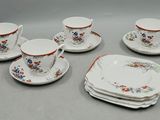 cinq tasses et une soucoupe sur la table