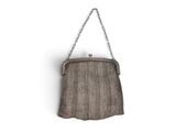 un sac à main marron accroché au mur par une chaîne