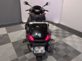 a black scooter parked in a room with a checkered floor