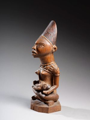 une statue en bois d'un homme avec un chapeau sur la tête