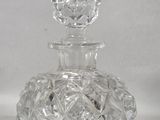 a clear glass bottle with a clear top on a white surface