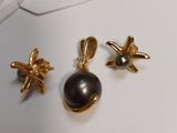 two pairs of gold and black pearl earrings on a white surface