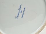 a white plate with a blue writing on it on a table