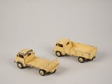 two toy trucks sitting next to each other on a white surface