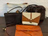 trois porte-monnaie et un sac à main posés sur une table en bois