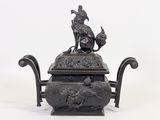 a statue of a man and a dog on top of a teapot