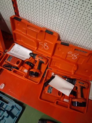 une boîte à outils orange, contenant des outils, posée sur une table