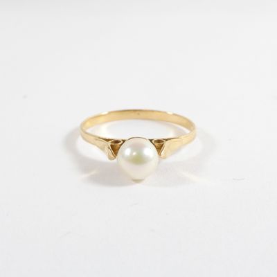 a gold ring with a pearl on top of it