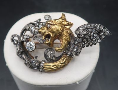 an image of a gold and silver broochle with wings