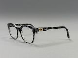 une paire de lunettes posée sur une surface blanche